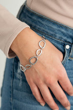 Load image into Gallery viewer, An array of irregular shaped silver rings link together and make their way around the wrist for a simple yet stylish avant-garde fashion. Features an adjustable clasp closure.