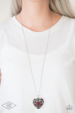 Load image into Gallery viewer, Vine-like filigree climbs the front of a locket inspired pendant for a vintage look. Featuring airy hearts on the back, the front of the dramatic pendant is sprinkled in glittery red rhinestones for a regal finish. Features an adjustable clasp closure. Sold as one individual necklace. Includes one pair of matching earrings.