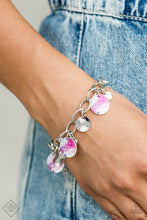 Load image into Gallery viewer, Featuring a galactic tie dye print, a collection of colorful and dainty silver discs swings from a bulky silver chain around the wrist for a trendy finish. Features an adjustable clasp closure.
