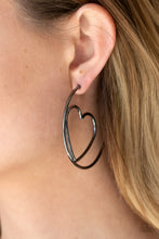 Load image into Gallery viewer, Glistening gunmetal wire delicately bends into an airy heart frame inside a classic gunmetal hoop, creating a flirtatious display. Earring attaches to a standard post fitting. Hoop measures approximately 2" in diameter. Sold as one pair of hoop earrings.
