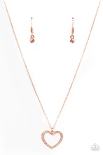 Load image into Gallery viewer, Encrusted in sparkly rhinestones, an airy shiny copper heart frame swings from a dainty shiny copper chain below the collar for a romantic look. Features an adjustable clasp closure. Sold as one individual necklace. Includes one pair of matching earrings.