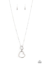 Load image into Gallery viewer, A silver heart engraved with the word "Grandma," dangles from two smaller hearts at the bottom of a lengthened silver chain. The first heart is accented with sparkly white rhinestones creating an affectionately sentimental pendant. Features an adjustable clasp closure. Sold as one individual necklace. Includes one pair of matching earrings.