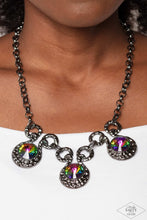 Load image into Gallery viewer, Three dramatically oversized oil spill rhinestones are nestled into three textured gunmetal fittings that are connected by oval gunmetal rings, creating a brilliant statement piece. Features an adjustable clasp closure. Due to its prismatic palette, color may vary. Sold as one individual necklace. Includes one pair of matching earrings.
