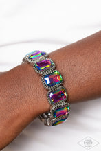 Load image into Gallery viewer, Oversized emerald style oil spill gems are encased in antiqued studded frames that are threaded along stretchy bands around the wrist, creating a smoldering centerpiece. Due to its prismatic palette, color may vary. Sold as one individual bracelet.