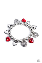 Load image into Gallery viewer, Decorative silver filigree, silver-studded, and red gem heart charms swing from a collection of shiny silver beads, and silver beads with a dot motif. Threaded along an elastic stretchy band, the charming bracelet creates a timeless romantic centerpiece around the wrist. Sold as one individual bracelet.
