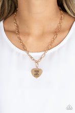 Load image into Gallery viewer, Dangling from a gold figaro chain, a charming heart pendant swings. Stamped upon the shiny surface, the phrase "Trust in the Lord" with the bible reference listed below it "Proverbs 3:5" are listed in different fonts for an optimistic and hopeful finish. Features an adjustable clasp closure. Sold as one individual necklace. Includes one pair of matching earrings.