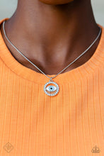 Load image into Gallery viewer, A light blue eye pendant is accented by silver edging and then wrapped in a circular border of brilliant white rhinestones. The sparkling charm slides effortlessly along a dainty snake chain, adding eye-catching movement to the design. Features an adjustable clasp closure. Includes one pair of matching earrings.