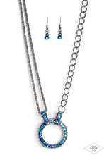 Load image into Gallery viewer, A collision of mismatched gunmetal chains gives way to a studded gunmetal pendant that has been encrusted in glittery blue UV rhinestones. The result is a gritty, industrial design with endless attitude. Features an adjustable clasp closure. Sold as one individual necklace. Includes one pair of matching earrings.