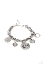 Load image into Gallery viewer, A collection of refined charms add some texture and shimmer to this monochromatic mash-up. An oversized, hammered disc is stamped with the phrase "be still" with the scripture reference "Psalm 48:10" listed underneath it. A smaller, hammered disc with a sprinkle of white rhinestones in its center and a silver disc featuring a scalloped ring in its center glide next to the oversized silver disc. A silver ring with serrated texture, and a silver disc with hammering and ring of white rhinestones glimmers.