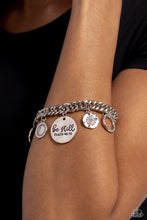 Load image into Gallery viewer, A collection of refined charms add some texture and shimmer to this monochromatic mash-up. An oversized, hammered disc is stamped with the phrase "be still" with the scripture reference "Psalm 48:10" listed underneath it. A smaller, hammered disc with a sprinkle of white rhinestones in its center and a silver disc featuring a scalloped ring in its center glide next to the oversized silver disc. A silver ring with serrated texture, and a silver disc with hammering and ring of white rhinestones glimmers.
