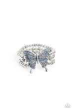 Load image into Gallery viewer, Strung along elastic stretchy bands, a trio of silver and textured silver beads and accents wrap around the wrist. Featured atop the beaded collection, an oversized silver butterfly, with intricate details, is sprinkled with dainty blue iridescent rhinestones across its wings and body, for a dramatically dazzling finish. Due to its prismatic palette, color may vary. Sold as one individual bracelet.