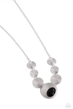 Load image into Gallery viewer, Embossed in an elongated dotted motif, a rustic collection of silver discs in varying sizes ruggedly links below the collar for an artisan inspired fashion. A faceted, oval, black gem sits at an angle on the biggest disc for a dauntless pop of color against the neckline. Features an adjustable clasp closure. Sold as one individual necklace. Includes one pair of matching earrings.