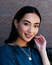 Load image into Gallery viewer, Infused on a classic silver chain, a strand of thick silver curb chain, and a collection of exaggerated, smoky radiant-cut gems in silver pronged fittings combine to create a collision of industrial color around the neckline. An oversized silver lock charm, embossed in white rhinestones, dangles from the gritty display for a touch of soft glitz to the design. Features an adjustable clasp closure. Sold as one individual necklace. Includes one pair of matching earrings.