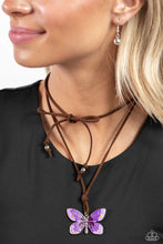 Load image into Gallery viewer, Featuring an ombre effect of lavender to purple to plum and accents of Leek Green, a vivacious oversized butterfly flutters at the bottom of a knotted lengthened strand of brown suede for a wanderlust statement. Features an adjustable tie closure. Sold as one individual necklace. Includes one pair of matching earrings.