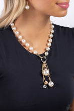 Load image into Gallery viewer, White pearls trickle below the collar attaching to a gold hoop as it nears the center of the chest. Accented with oversized white pearls, rhinestone-encrusted gold beads, faceted clear beads, and strands of gold chains cascade from the bottom of the gold hoop creating a charming, refined display. Features a clasp closure. Sold as one individual necklace. Includes one pair of matching earrings.