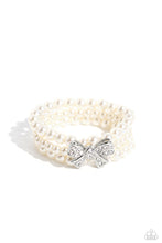 Load image into Gallery viewer, Strung along elastic stretchy bands, three strands of high-sheen classic white pearls wrap around the wrist. Featured atop the pearly collection, a loopy silver bow, filled with glistening white rhinestones is attached to the center of the wrist for a dramatically dazzling finish. Sold as one individual bracelet.