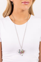 Load image into Gallery viewer, Featuring blue, fuchsia, olive, and rose rhinestones, the word "LOVE" floats inside an oversized, airy heart-shaped frame as it sways from a lengthened silver chain for a Valentine's-inspired centerpiece. Features an adjustable clasp closure. Sold as one individual necklace. Includes one pair of matching earrings.