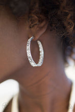 Load image into Gallery viewer, The front facing surface of a chunky silver hoop is dipped in brilliantly sparkling rhinestones while light-catching texture wraps around the back. The interior of the hoop features the opposite pattern, creating the illusion of a full hoop of blinding Blockbuster rhinestones. Earring attaches to a standard post fitting. Hoop measures 1 3/4" in diameter. Sold as one pair of hoop earrings.