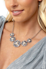 Load image into Gallery viewer, Sleek metal bars flare out from a mesmerizing pearl center, creating a blue and white stacked rhinestone-encrusted fringe of fanning frames. A trio of emerald-cut white gem bars are sprinkled across each dazzling display for a sassy finish. Features an adjustable clasp closure. Includes one pair of matching earrings.