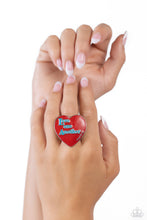 Load image into Gallery viewer, Stamped atop an oversized, red-painted heart, the phrase "Love one Another" is featured in a blue hue. The scripture reference, "John 13:34," curves up one side of the red heart frame in silver letters atop airy silver bands for a religious-inspired centerpiece. Features a stretchy band for a flexible fit. Sold as one individual ring.