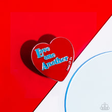 Load image into Gallery viewer, Stamped atop an oversized, red-painted heart, the phrase "Love one Another" is featured in a blue hue. The scripture reference, "John 13:34," curves up one side of the red heart frame in silver letters atop airy silver bands for a religious-inspired centerpiece. Features a stretchy band for a flexible fit. Sold as one individual ring.