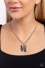 Load image into Gallery viewer, Gliding along a classic silver chain, a black-painted word pendant spells out the word "LOVE" with a brown-painted and silver-detailed football replacing the "O" for a sports-inspired centerpiece. Features an adjustable clasp closure. Sold as one individual necklace. Includes one pair of matching earrings.