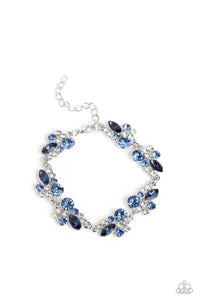 An eclectic collection of white and blue round rhinestones in varying sizes and marquise-cut gems in a blue shade cluster around the wrist in high-sheen silver frames. Patterned in an abstract manner, the clusters interlock together, emitting light from every faceted angle. Features an adjustable clasp closure.