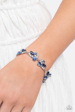 Load image into Gallery viewer, An eclectic collection of white and blue round rhinestones in varying sizes and marquise-cut gems in a blue shade cluster around the wrist in high-sheen silver frames. Patterned in an abstract manner, the clusters interlock together, emitting light from every faceted angle. Features an adjustable clasp closure.
