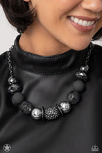Load image into Gallery viewer, Sophisticated beads in shades of gunmetal and black with reflective faceted edges and varying glazed finishes are offset by two shiny silver beads. An oblong bead studded with gunmetal rhinestones adds a dramatic accent. Features an adjustable clasp closure.  Sold as one individual necklace. Includes one pair of matching earrings.
