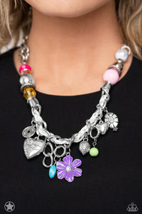 White cording is braided through a chunky silver chain. A unique variety of colorful charms decorate the piece including a delicate flower and a heart inscribed with the phrase "With All My Heart" on one side and a short bible verse on the other that reads, "Love the Lord thy God with all your heart. Luke 10:27." Features an adjustable clasp closure.  Sold as one individual necklace. Includes one pair of matching earrings.