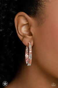 The front facing surface of a chunky shiny copper hoop is dipped in brilliantly sparkling iridescent, peach, and white rhinestones while light-catching texture wraps around the back. The interior of the hoop features the opposite pattern, creating the illusion of a full hoop of blinding rhinestones. Earring attaches to a standard post fitting. Hoop measures 1 3/4" in diameter. Due to its prismatic palette, color may vary.  Sold as one pair of hoop earrings.