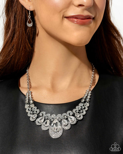 Pressed in thin, curly silver infinity-like frames, solitaire white rhinestones gradually elongate into faceted shimmery teardrop gems. A collection of dainty, airy white rhinestones dusts the caps of each teardrop frame for additional glitz and glamor. Features an adjustable clasp closure. Sold as one individual necklace. Includes one pair of matching earrings.
