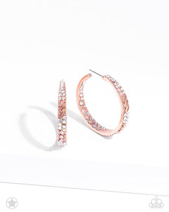 The front facing surface of a chunky shiny copper hoop is dipped in brilliantly sparkling iridescent, peach, and white rhinestones while light-catching texture wraps around the back. The interior of the hoop features the opposite pattern, creating the illusion of a full hoop of blinding rhinestones. Earring attaches to a standard post fitting. Hoop measures 1 3/4" in diameter. Due to its prismatic palette, color may vary.  Sold as one pair of hoop earrings.