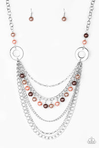 Dramatic silver hoops give way to layers of mismatched silver chains. Pearly brown, pink, and tan beads trickle from the second chain, creating a flirty fringe across the chest. Features an adjustable clasp closure.  Sold as one individual necklace. Includes one pair of matching earrings.