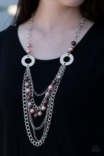 Load image into Gallery viewer, Dramatic silver hoops give way to layers of mismatched silver chains. Pearly brown, pink, and tan beads trickle from the second chain, creating a flirty fringe across the chest. Features an adjustable clasp closure.  Sold as one individual necklace. Includes one pair of matching earrings.
