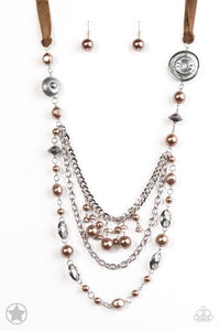 A silky brown ribbon replaces a traditional chain to give an elegant look. Pearly brown beads and funky silver pieces intermix with varying lengths of silver chains to give a fresh take on a Victorian-inspired Blockbuster piece.   Sold as one individual necklace. Includes one pair of matching earrings.