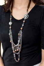 Load image into Gallery viewer, A silky brown ribbon replaces a traditional chain to give an elegant look. Pearly brown beads and funky silver pieces intermix with varying lengths of silver chains to give a fresh take on a Victorian-inspired Blockbuster piece.   Sold as one individual necklace. Includes one pair of matching earrings.

