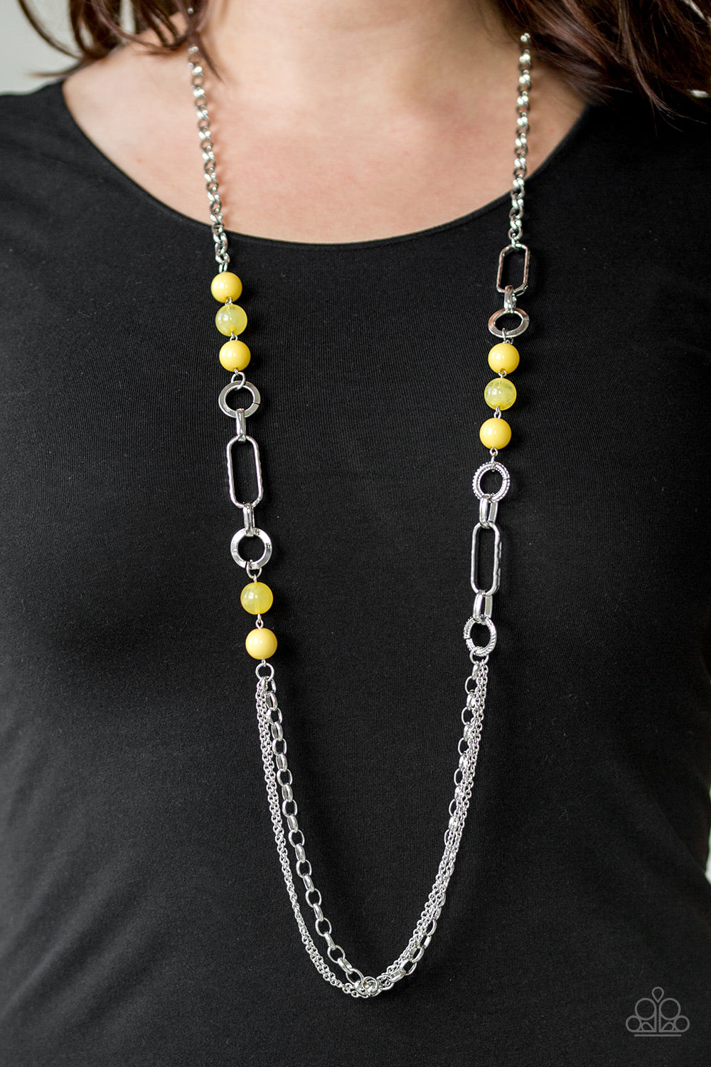 A collection of glassy and polished yellow beads give way to layers of mismatched silver chain for a whimsical look. Features an adjustable clasp closure.  Sold as one individual necklace. Includes one pair of matching earrings.