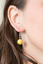 Load image into Gallery viewer, Yellow bead hanging from a silver fish hook earring.
