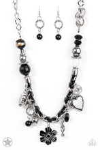 Load image into Gallery viewer, Black and ivory cording is braided through a chunky silver chain. A unique variety of charms decorate the Blockbuster piece, including a delicate flower and a heart. Heart is inscribed with the phrase &quot;With All My Heart&quot; on one side and a short bible verse on the other that reads, &quot;Love the Lord thy God with all your heart. Luke 10:27.&quot; Features an adjustable clasp closure. Sold as one individual necklace. Includes one pair of matching earrings.

