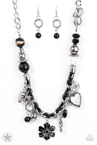 Black and ivory cording is braided through a chunky silver chain. A unique variety of charms decorate the Blockbuster piece, including a delicate flower and a heart. Heart is inscribed with the phrase "With All My Heart" on one side and a short bible verse on the other that reads, "Love the Lord thy God with all your heart. Luke 10:27." Features an adjustable clasp closure. Sold as one individual necklace. Includes one pair of matching earrings.