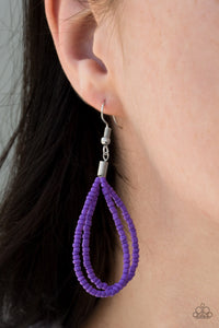 Purple seed bead circle hanging from a silver fish hook earring.