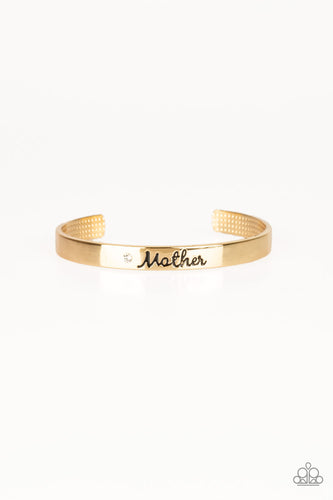 A sleek gold cuff wraps around the wrist in a casual fashion. Dotted with a dainty white rhinestone, the shimmery cuff is engraved in the word “Mother” for a loving finish.  Sold as one individual bracelet.