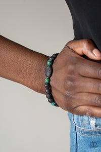 A collection of black lava rocks and earthy green stone beads are threaded along a stretchy band around the wrist for a seasonal look. Sold as one individual bracelet.