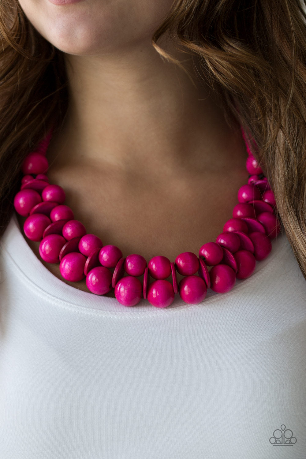 Brushed in a distressed finish, vivacious pink wooden beads and discs join below the collar for a summery look. Features a button loop closure.  Sold as one individual necklace. Includes one pair of matching earrings.