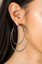 Load image into Gallery viewer, Featuring diamond-cut textures, two glistening gunmetal bars curl into a bold hoop for a flawless finish. Earring attaches to a standard post fitting. Hoop measures 2 3/4” in diameter. Sold as one pair of hoop earrings.
