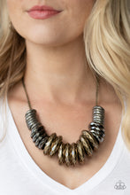 Load image into Gallery viewer, Gradually increasing in size, a collision of faceted tin finished silver, gunmetal, and brass rings slide along a classic brass chain below the collar for a bold industrial look. Features an adjustable clasp closure.  Sold as one individual necklace. Includes one pair of matching earrings.
