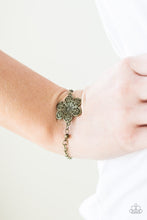 Load image into Gallery viewer, Featuring filigree filled petals, a glistening brass flower adorns the center of the wrist for a seasonal look. Features an adjustable clasp closure.
