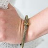 Load image into Gallery viewer, Shimmery brass mesh chain joins into a thick bangle around the wrist. Encrusted in glittery aurum rhinestones, a brass ring slides along the bangle, adding sassy sparkle to the edgy palette. Sold as one individual bracelet.
