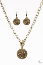 Load image into Gallery viewer, Embossed in a whimsical rosebud pattern, a shimmery brass frame swings below the collar for a casual look. Features a toggle closure. Sold as one individual necklace. Includes one pair of matching earrings.
